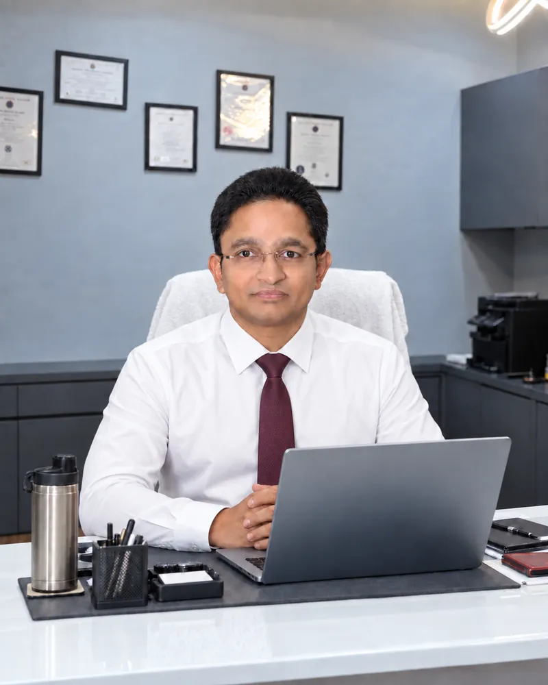 CA Kureen Goyal seated at his office desk in a white shirt and tie